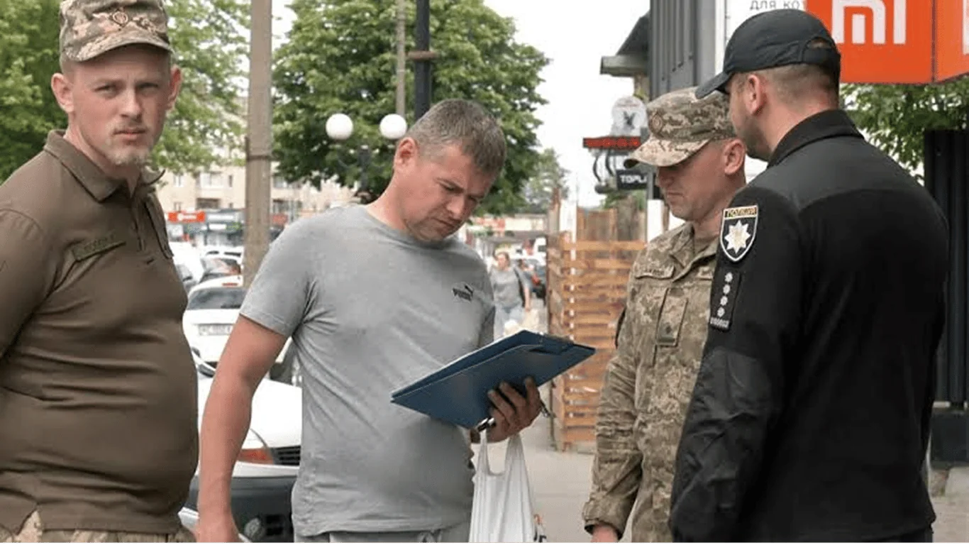 Військові та поліцейський перевіряють документи цивільного на вулиці міста